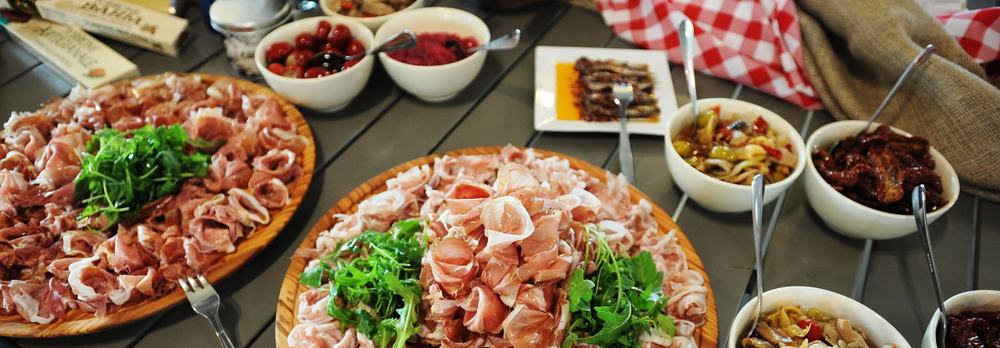 Stůl s uzeninami, sýry a antipasti při degustaci